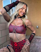 Stylish model wearing a red spiral-patterned rave outfit with accessories, showcasing trendy dance floor attire.