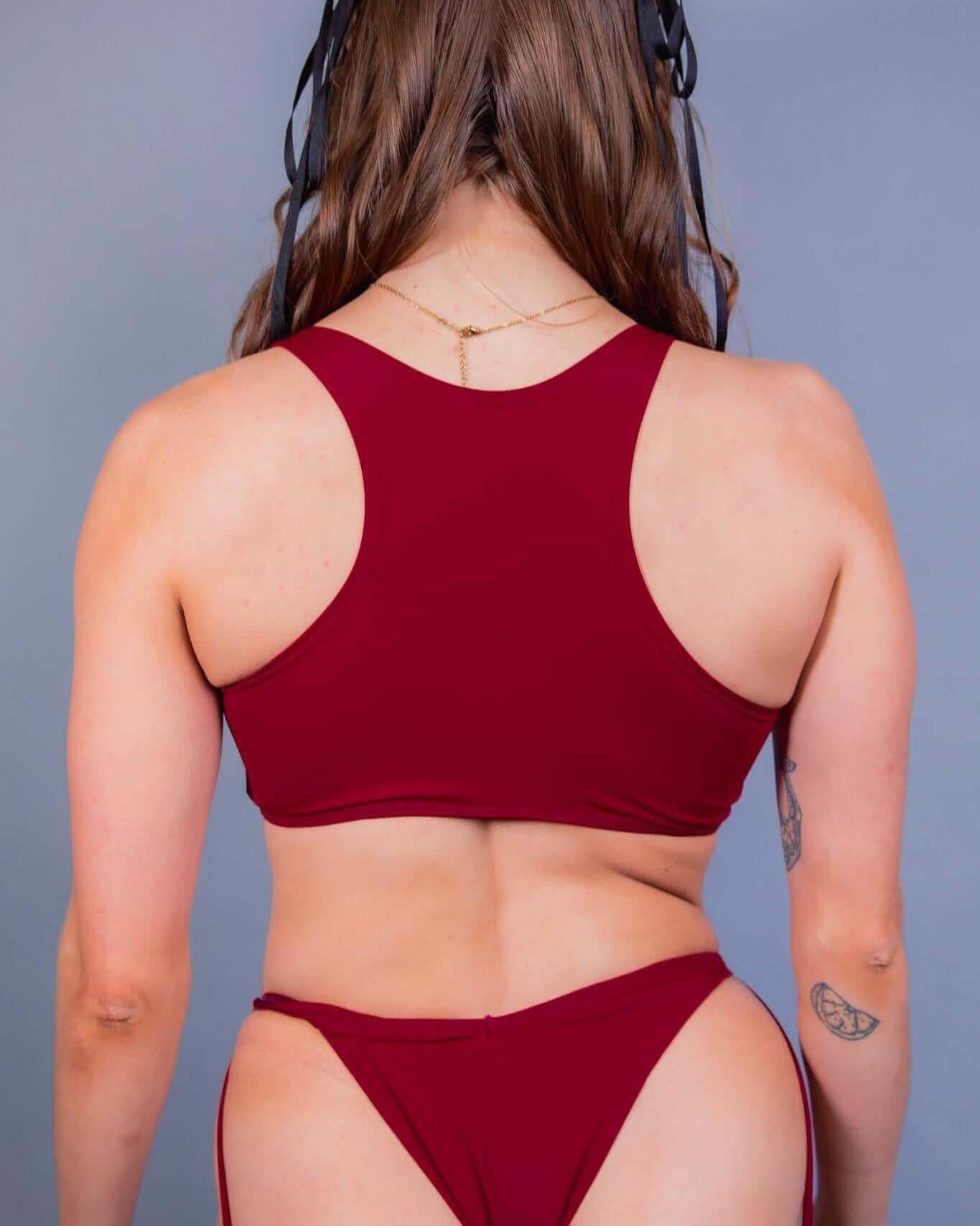 Back view of a model in a scarlet cutout teaser top, showcasing the racerback design and underboob look. Ideal for rave outfits.