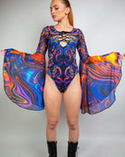 Model wearing the vibrant ShadowFlame Goddess Bodysuit, showcasing lace-up detail and flowing circle sleeves for rave outfits.