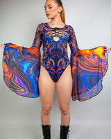 Model wearing the vibrant ShadowFlame Goddess Bodysuit, showcasing lace-up detail and flowing circle sleeves for rave outfits.