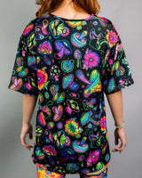 Colorful oversized tee featuring trippy mushroom and flower prints, perfect for rave outfits and vibrant style.