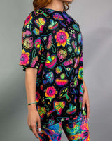 Model wearing Shroomie! Oversized Softee with vibrant mushroom print, paired with colorful rave leggings. Perfect for festivals.