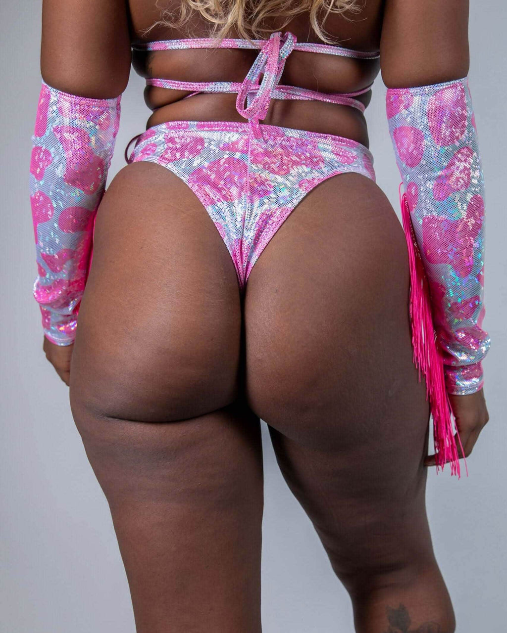 Model showcasing a sparkly pink cow print high waisted thong, perfect for rave outfits.