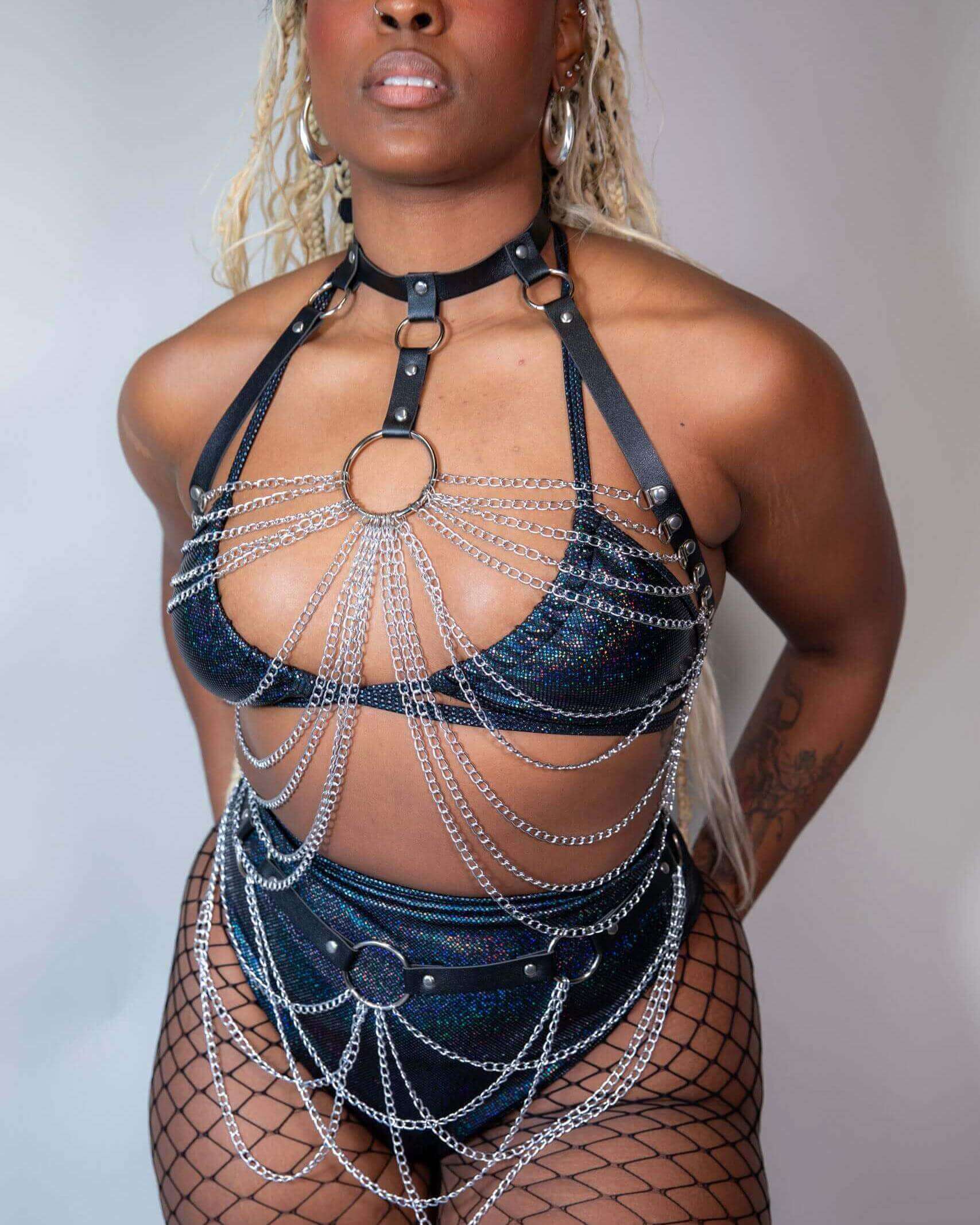 Model showcasing a stylish rave outfit featuring a chain design and edgy accessories, perfect for festival fashion.