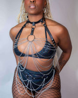 Model showcasing a stylish rave outfit featuring a chain design and edgy accessories, perfect for festival fashion.