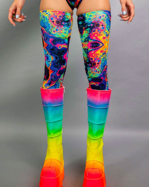 Vivid leg sleeves in colorful psychedelic design paired with vibrant rainbow platform boots, perfect for rave outfits.