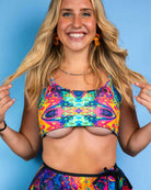 Model showcasing the Vivid Shroomie! Reversible Lush Top with vibrant rainbow mushroom prints, perfect for rave outfits.