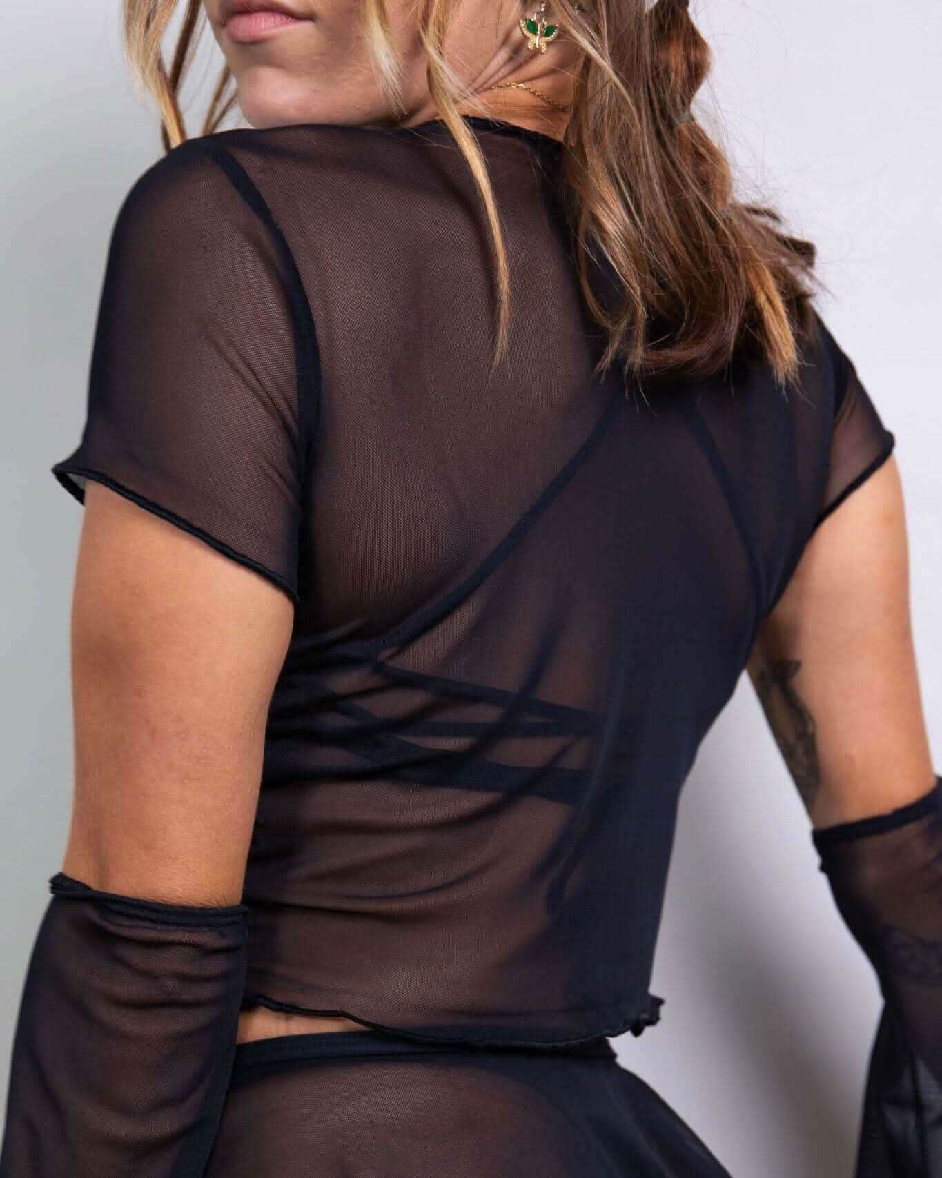 Black mesh baby tee showcasing cap sleeves and merrow hem, perfect for rave outfits and layered looks.