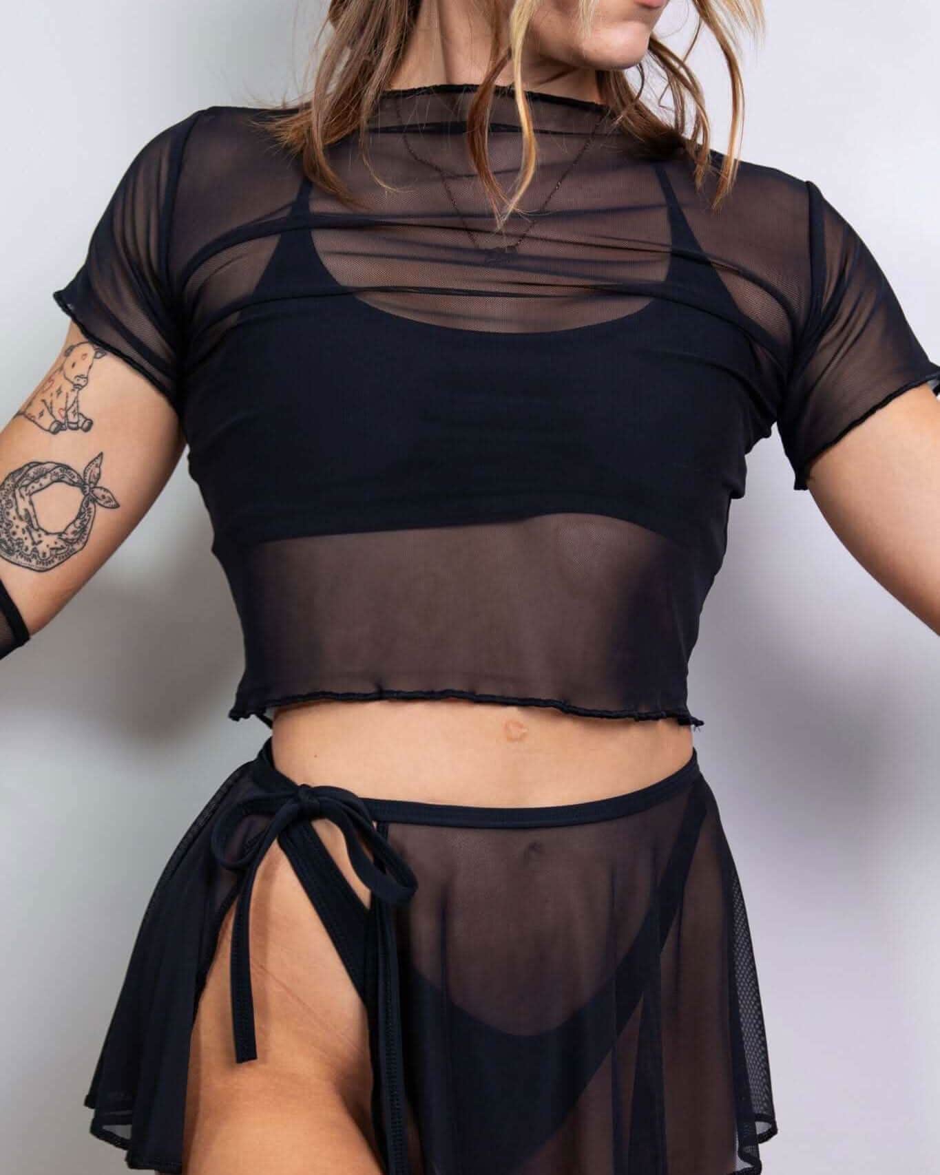 Black mesh baby tee layered over a matching sheer skirt, perfect for rave outfits and stylish summer looks.