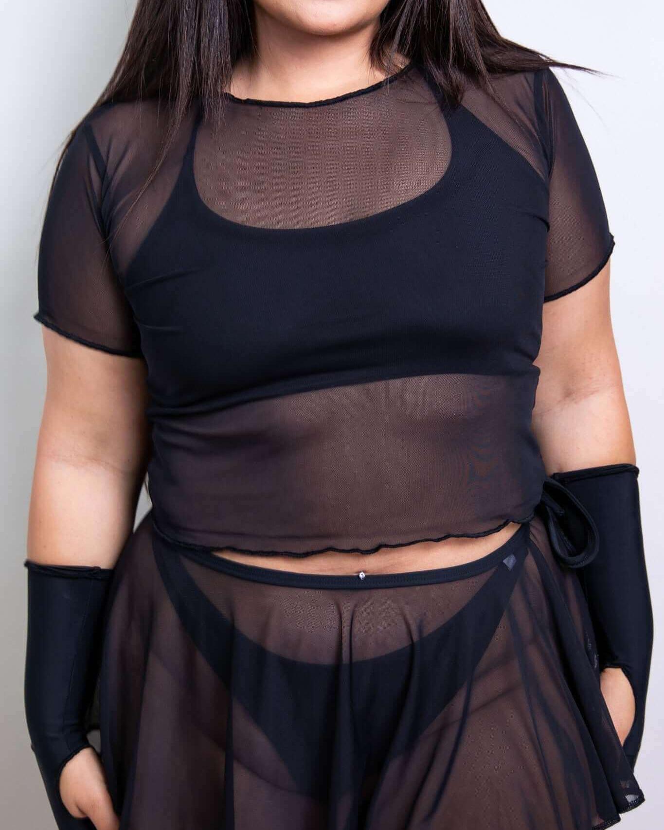 Black mesh crop top with cap sleeves paired with a matching skirt, ideal for rave outfits and layered looks.