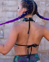 Woman in a black mesh bikini top and colorful high-waisted bottoms, showcasing adjustable straps, perfect for rave outfits.