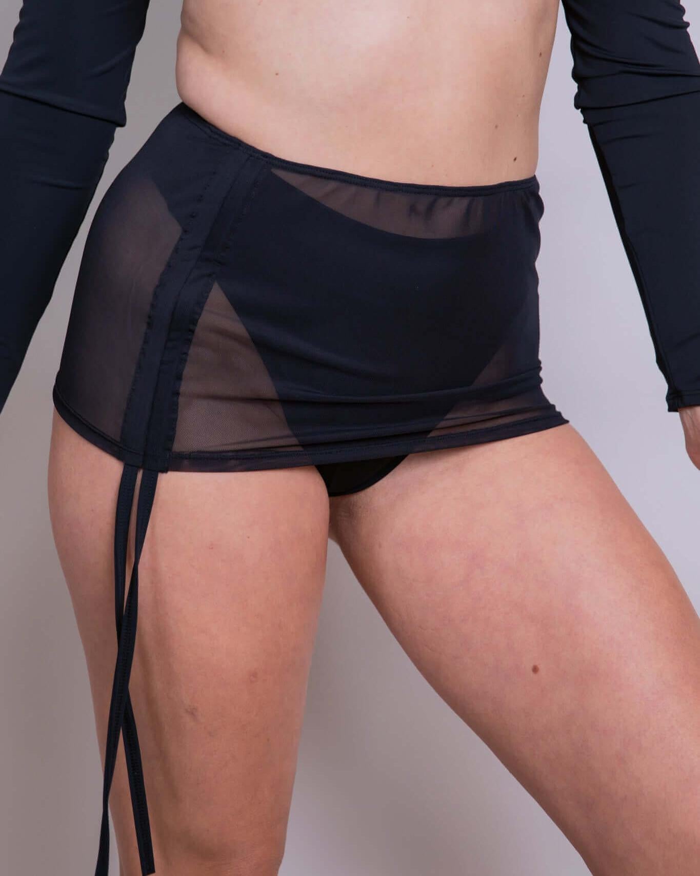 Black mesh cinch skirt with adjustable drawcord for customizable length, perfect for rave outfits and all occasions.