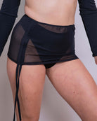 Black mesh cinch skirt with adjustable drawcord for customizable length, perfect for rave outfits and all occasions.