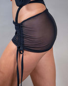 Black mesh cinch skirt showcasing adjustable tie details and ruched effect, perfect for rave outfits.