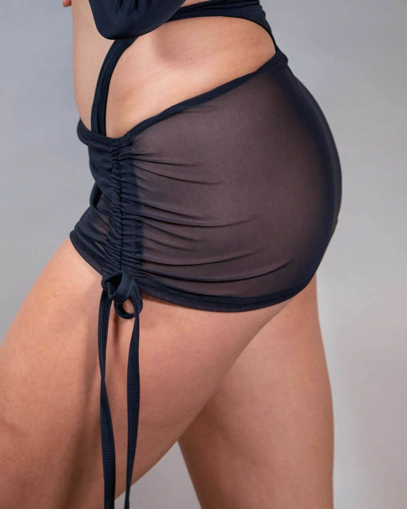 Black mesh cinch skirt showcasing adjustable tie details and ruched effect, perfect for rave outfits.