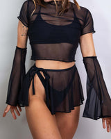 Model wearing black mesh flare sleeves with a matching sheer top and skirt, showcasing stylish rave outfit.
