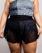 Black mesh skater skirt paired with geometric patterned top, perfect for rave outfits and stylish casual wear.