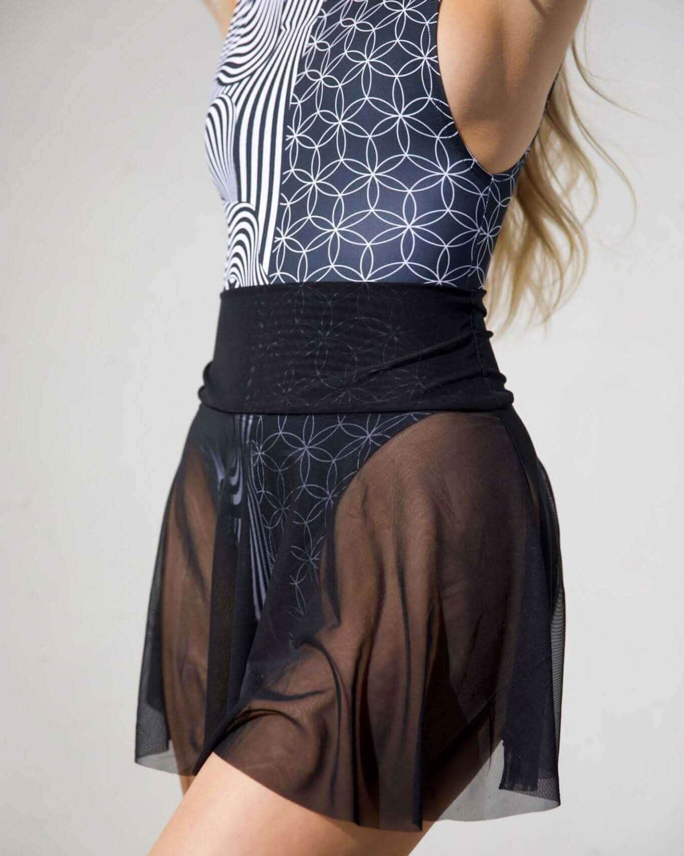 Stylish model showcasing a black mesh skater skirt paired with a patterned bodysuit for a trendy look.