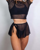 Model wearing a black mesh swirl skirt and mesh top, showcasing a stylish rave outfit for layered summer looks.