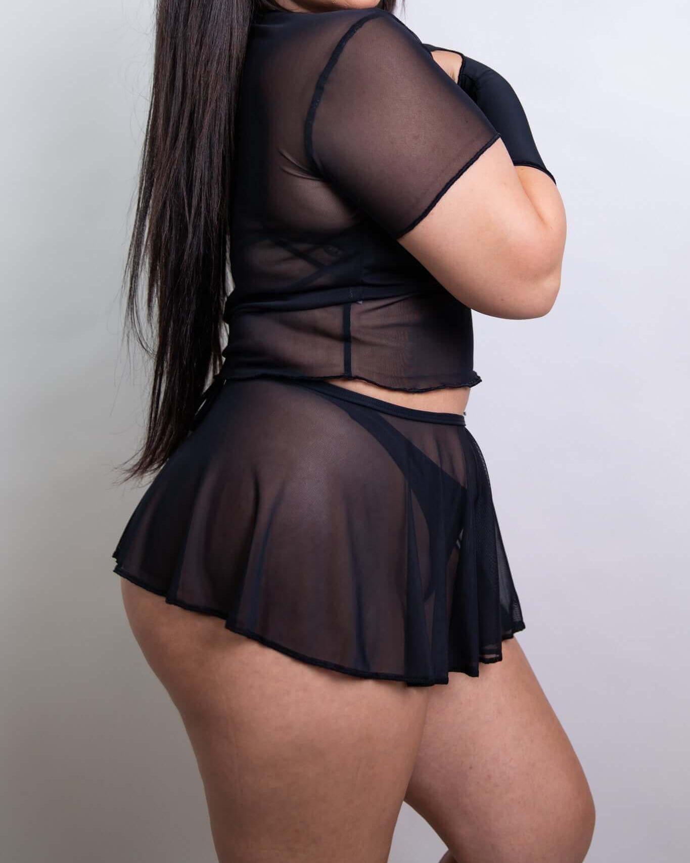 Black mesh swirl skirt paired with a sheer crop top, ideal for rave outfits and stylish layering.