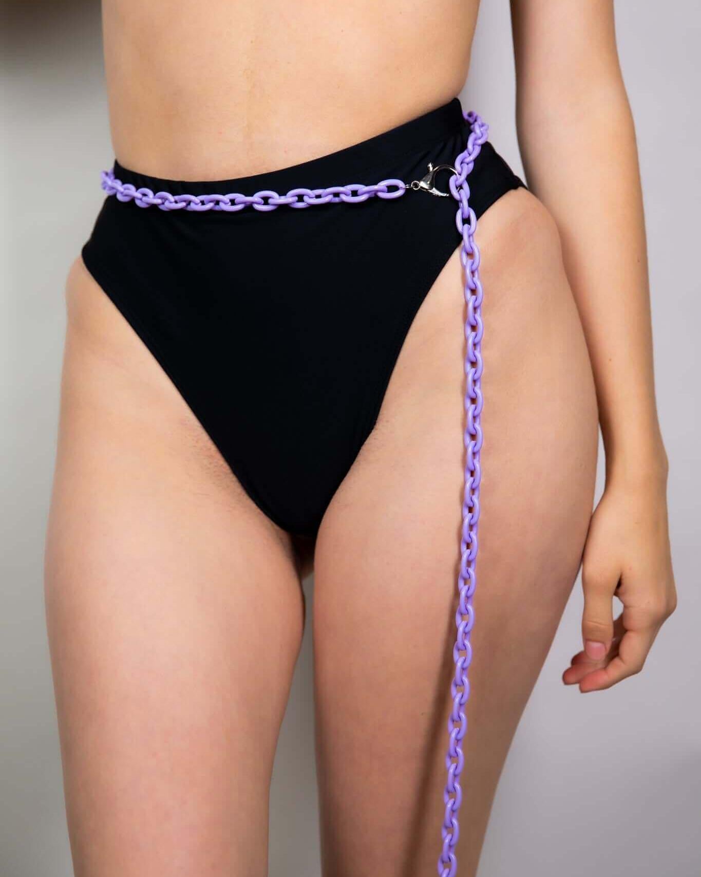 Purple chain belt styled with high-waisted black bikini bottom, perfect for rave outfits and festival fashion.
