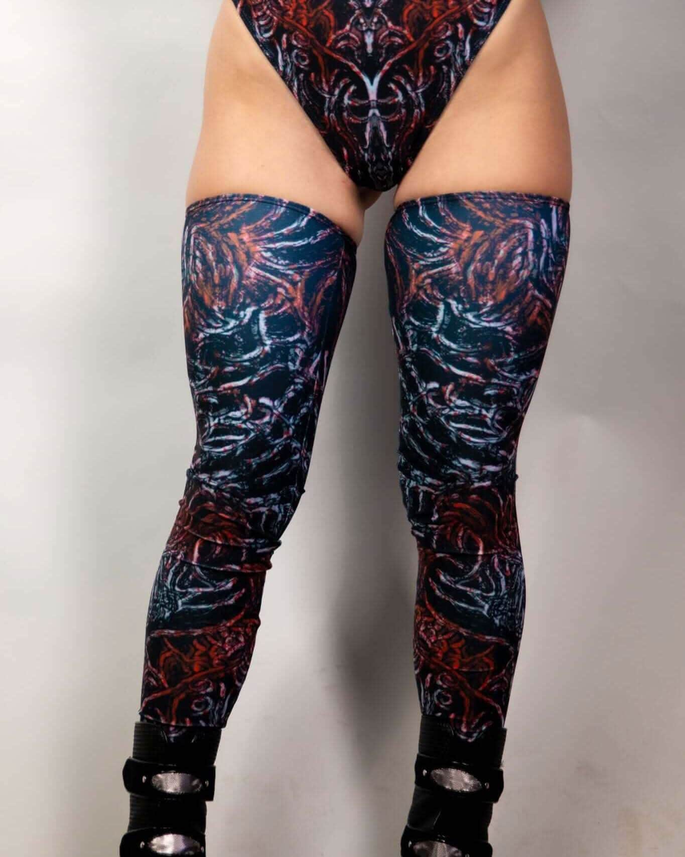 Rave-ready Darkness leg sleeves in striking patterns, paired with stylish high-cut bottoms and edgy footwear.