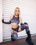 Model showcasing FRW's vibrant rave outfit with intricate patterns, posing in stylish black platform boots.