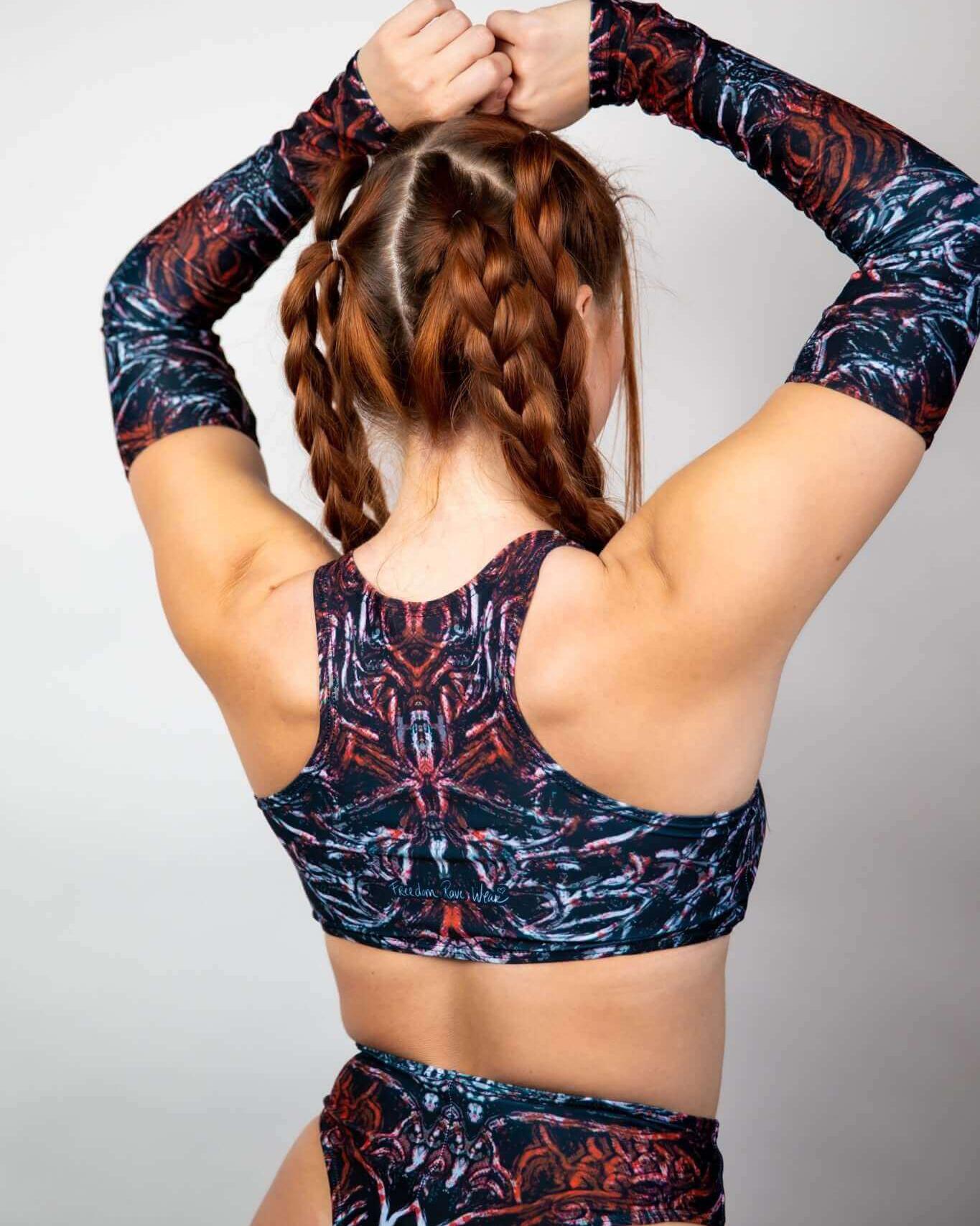 Model showcasing the Darkness Teaser Top with unique patterns, featuring high neck and racerback design, perfect for rave outfits.