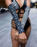 Model wearing Duality Arm Sleeves with black and white graphic print, showcasing rave outfit style in urban setting.