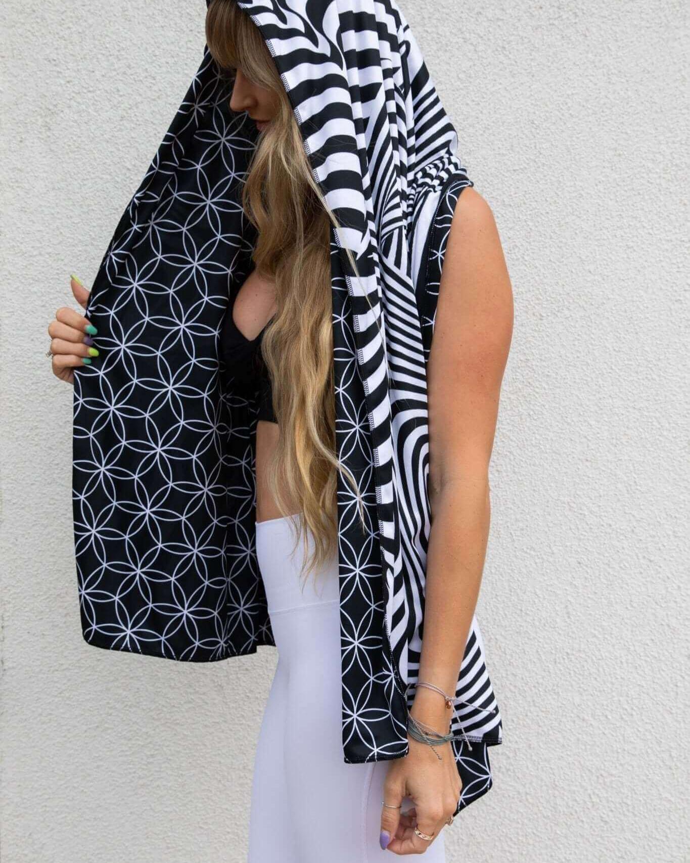 Woman showcasing dual-sided Duality Festival Scarf with Flower of Life and optical illusion patterns. Perfect for rave outfits.