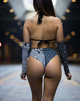 Woman wearing Duality High Waisted Brazilian Bottoms with black and white patterns, perfect for rave outfits.