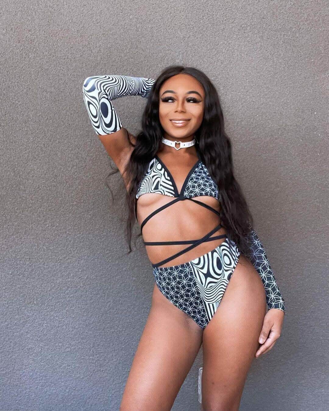 Model showcasing Duality High Waisted Brazilian Bottoms with a black and white trippy pattern, perfect for rave outfits.