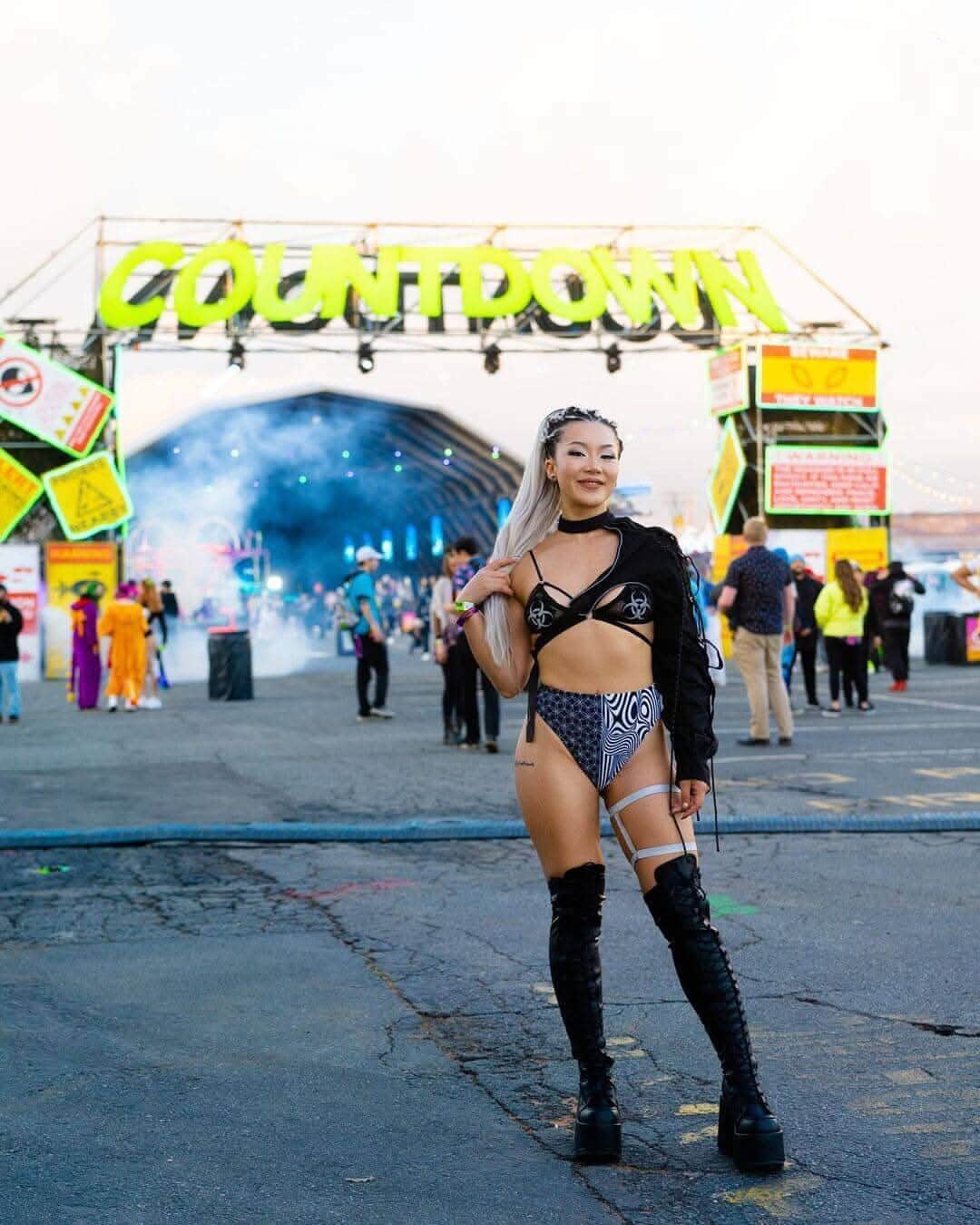 Woman in edgy rave outfit at Countdown festival, showcasing Duality High Waisted Brazilian Bottoms and vibrant stage backdrop.
