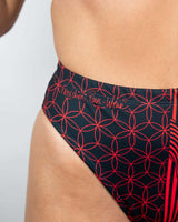 Close-up of high-waisted Brazilian bikini bottom featuring vibrant red and black floral design, perfect for rave outfits.