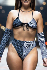 Model showcasing the Duality Wrap Bikini Top with black and white graphic design, perfect for stylish beachwear and rave outfits.