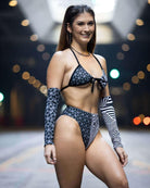 Model showcasing the Duality Wrap Bikini Top with black and white graphic design, perfect for summer rave outfits.