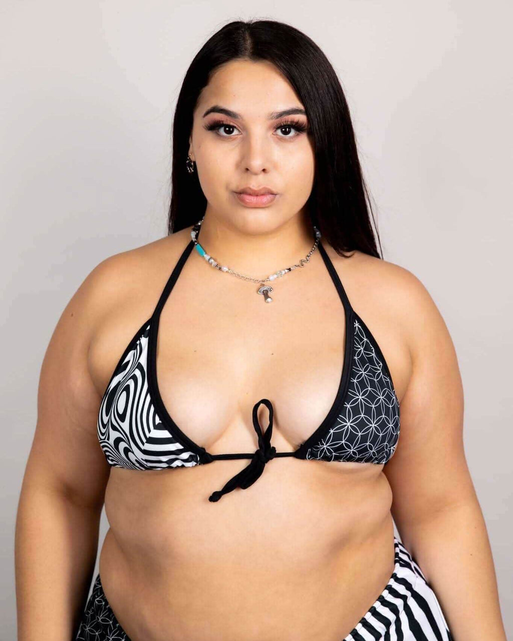 Model wearing FRW Exclusive Duality Wrap Bikini Top in black and white graphic design, perfect for rave outfits.