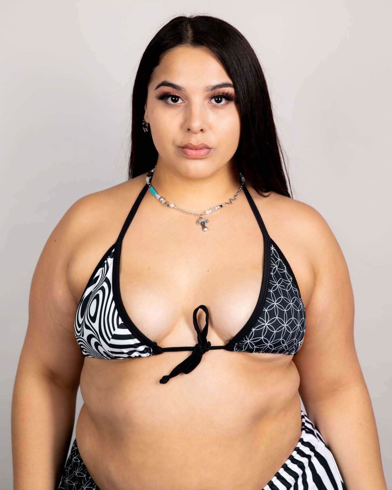 Model wearing FRW Exclusive Duality Wrap Bikini Top in black and white graphic design, perfect for rave outfits.