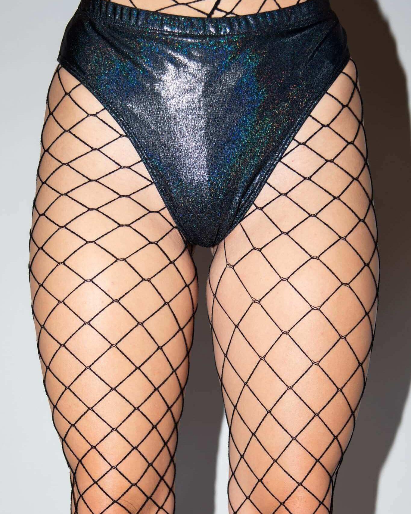 Black fishnets paired with shiny high-waisted bottoms, perfect for rave outfits and edgy festival looks.