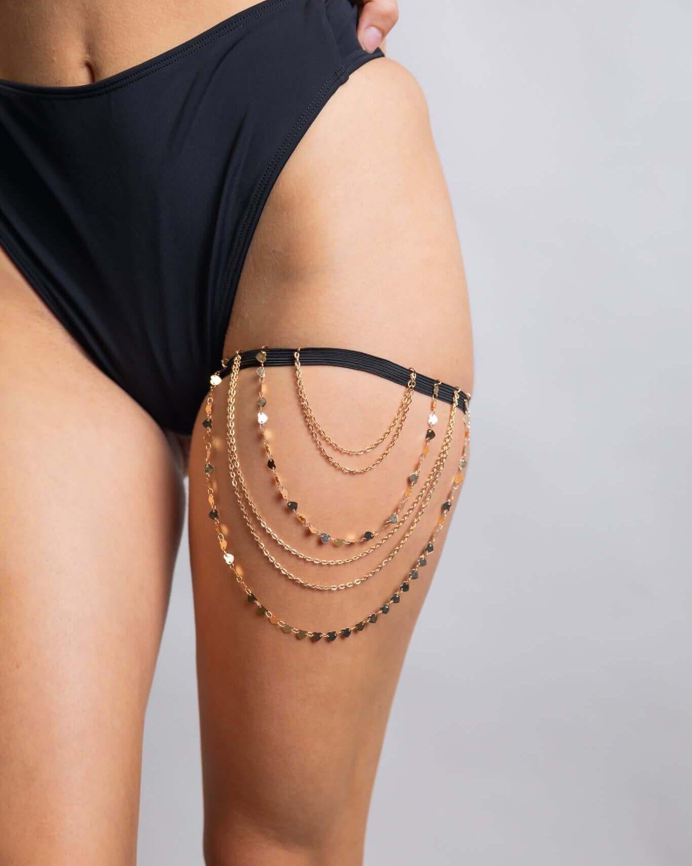 Gold chain leg garter worn with a black bikini, perfect accessory for stylish rave outfits.