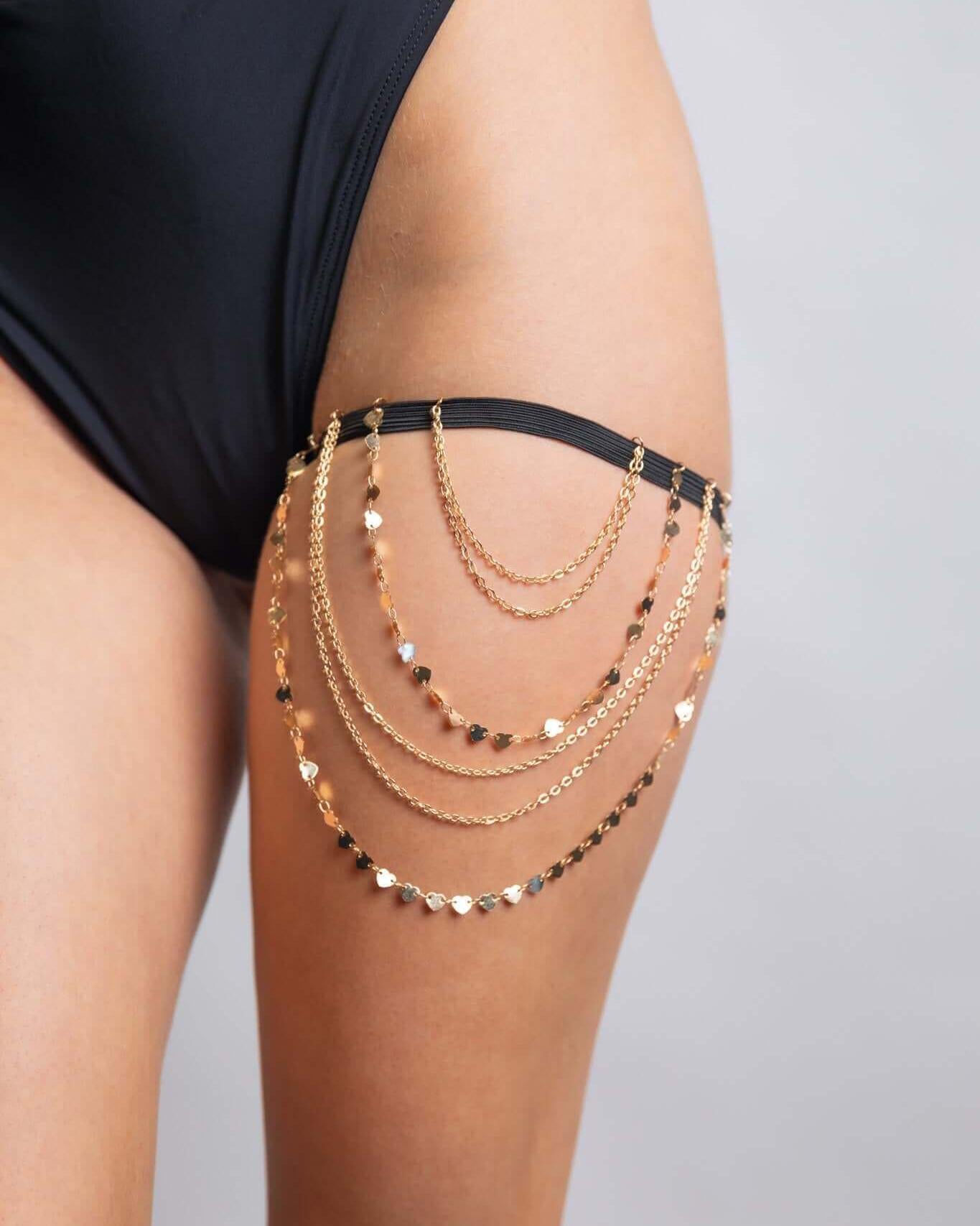 Gold chain leg garter on a thigh, perfect accessory for rave outfits and stylish looks.