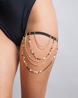 Gold chain leg garter on a thigh, perfect accessory for rave outfits and stylish looks.