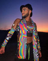 A model showcasing HAPPIER Arm Sleeves in a trippy rainbow design, perfect for vibrant rave outfits against a sunset backdrop.