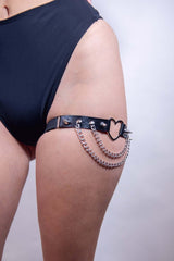 Black heart spike leg garter with chain detailing, perfect for bold rave outfits and edgy fashion statements.