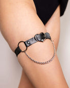 Black leather Heartbreaker leg garter with chain detail, perfect for rave outfits and festivals.