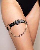 Heartbreaker Black Leg Garter with heart symbol and chain detail, perfect for adding flair to rave outfits.