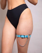 Heartbreaker blue leg garter with heart symbol and chain detail, perfect for rave outfits and festival fashion.