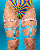 Heartbreaker leg garter in pink and blue worn over fishnet stockings, perfect for rave outfits and festival fashion.