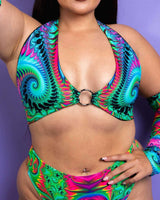 Model wearing a vibrant Hypnotic O Ring Halter Top, showcasing a colorful swirl design, perfect for rave outfits.