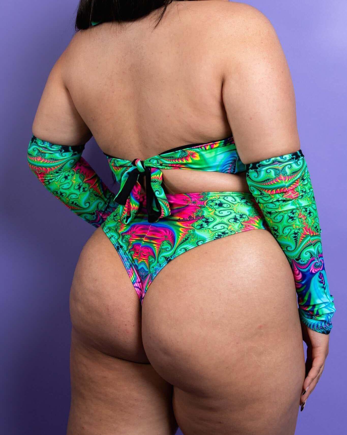 Rear view of a model in a vibrant printed halter top and matching bottoms, showcasing a stylish rave outfit.